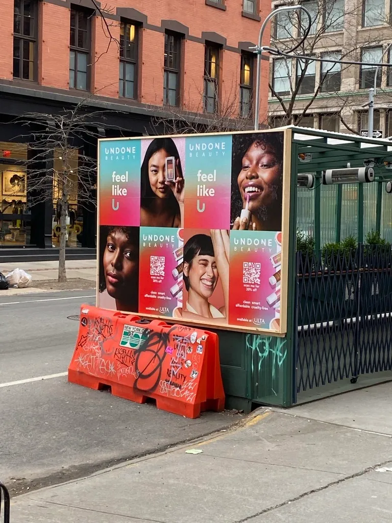Outdoor dining structure wrapped in a beauty brand campaign in New York City
